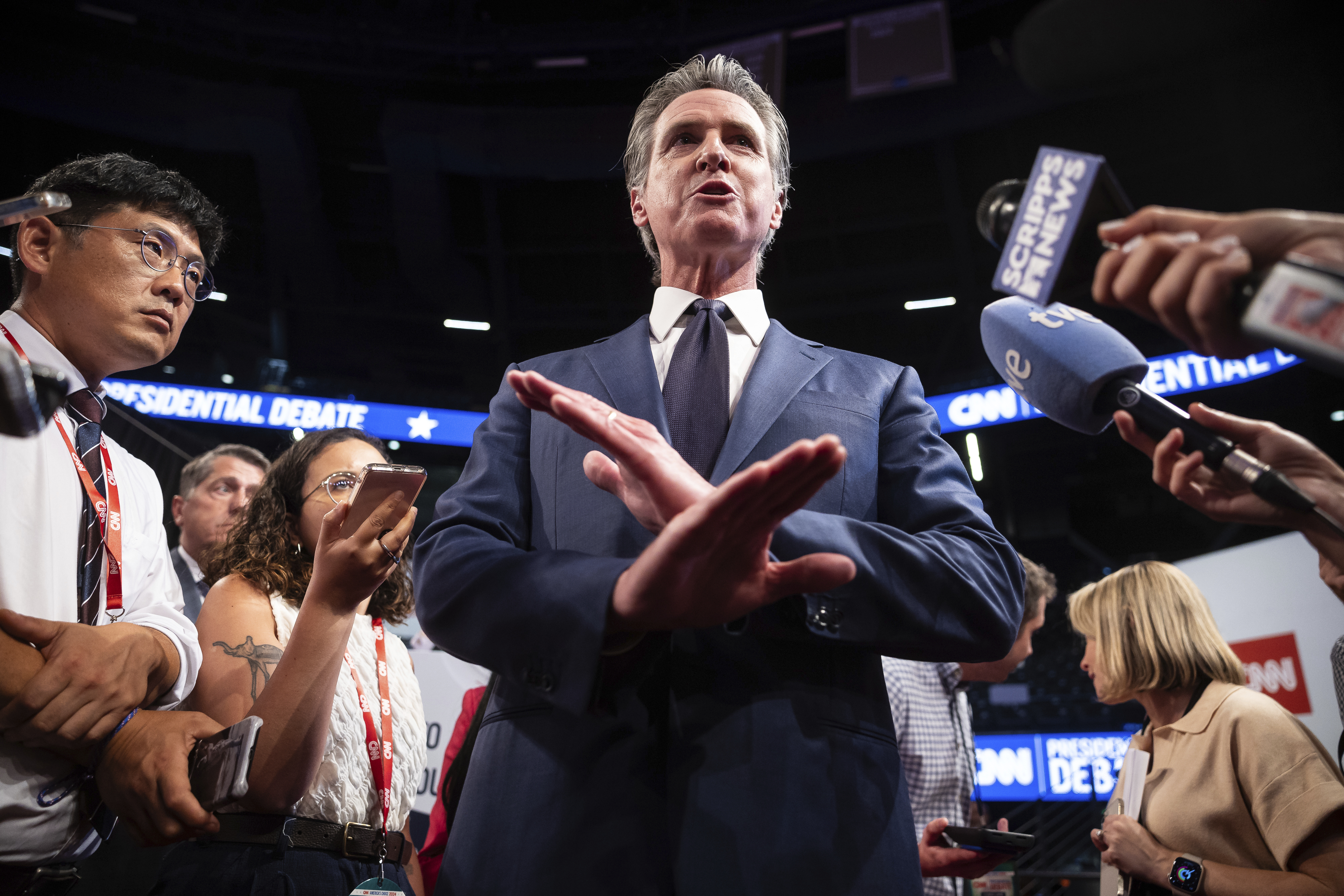 California Gov. Gavin Newsom speaks with journalists in the spin room at Georgia Institute of Technology's McCamish Pavilion.