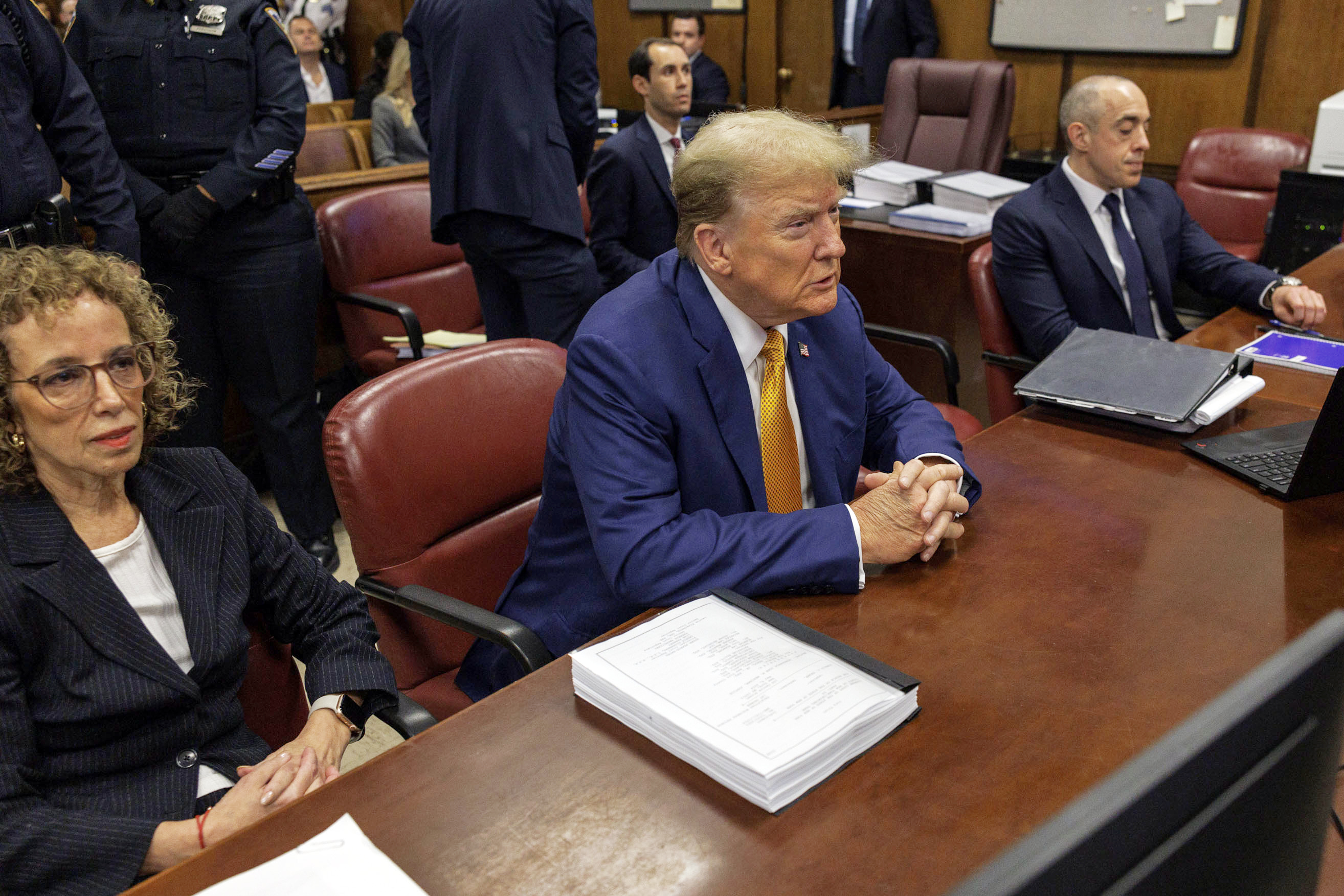 Former President Donald Trump sits at the defense table with his attorneys Susan Necheles and Emil Bove in Manhattan criminal court.