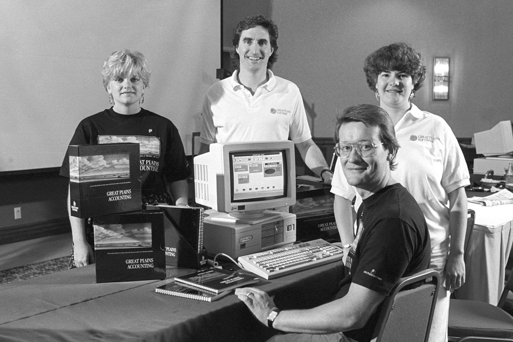 Doug Burgum (center) smiles for a photo with three other people at Great Plains Software.