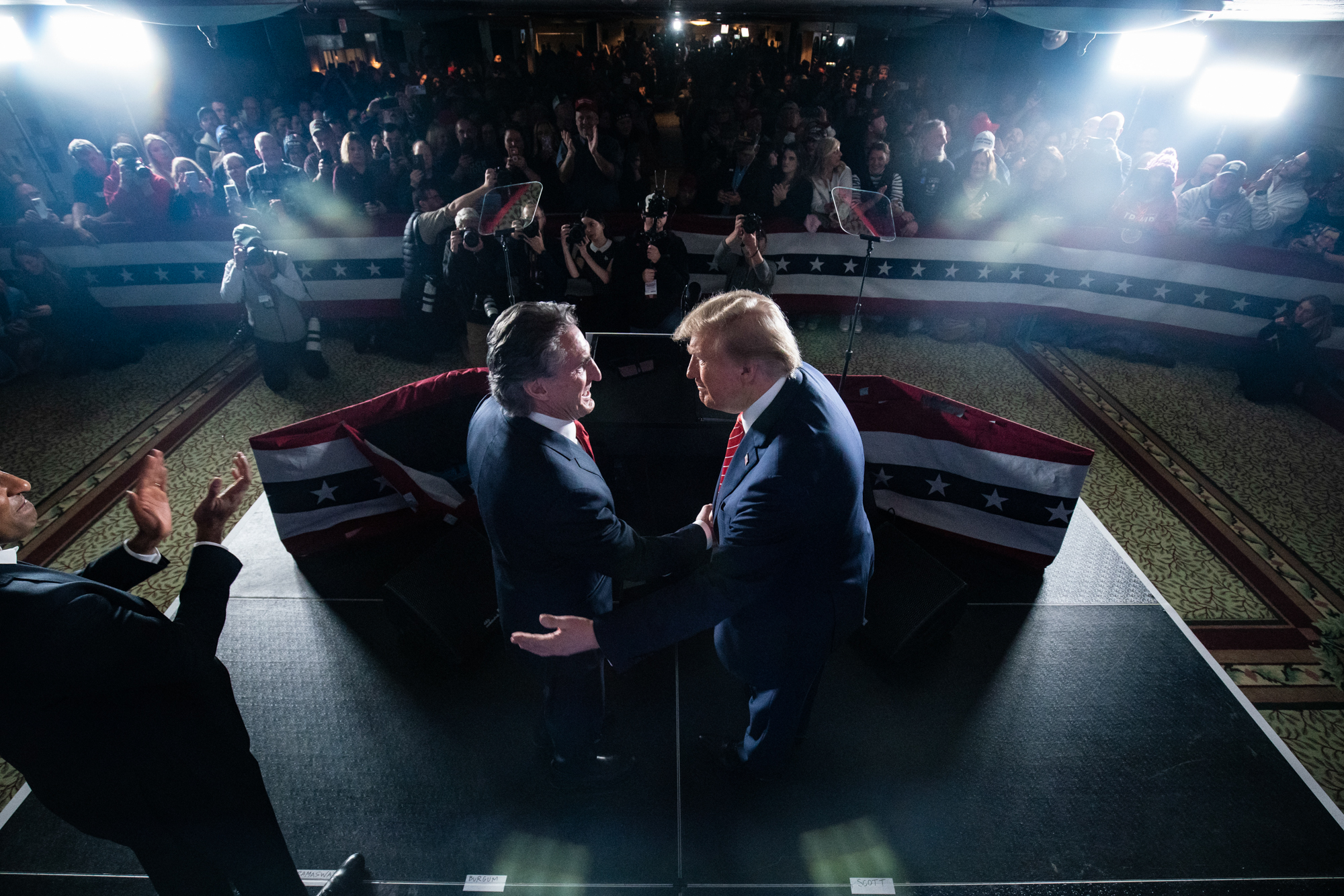 Donald Trump shakes hands with Doug Burgum during a campaign rally.