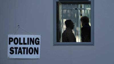 People vote in a temporary polling station next to Norbiton railway station London Thursday, July 4, 2024. Britain goes to the polls Thursday after Prime Minister Rishi Sunak called a general election. (AP Photo/Kin Cheung)