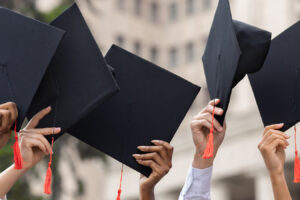 photo - group of graduation caps held by graduates