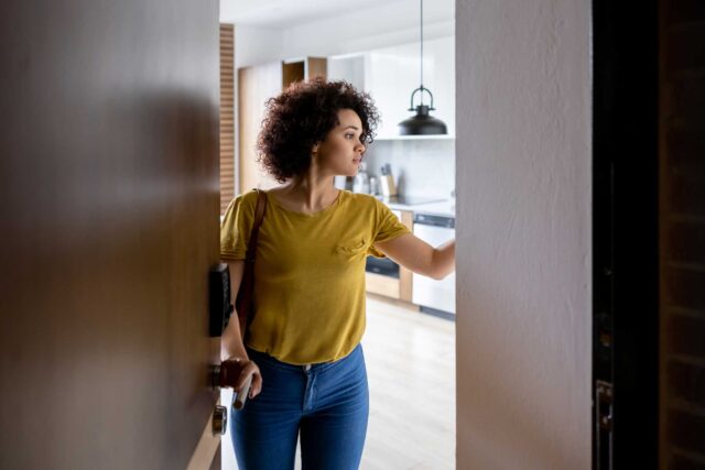 photo - Woman at Apartment Door Activating Alarm as Leaving