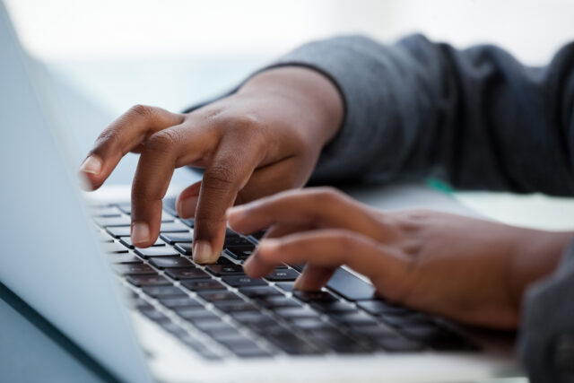 photo - Close Up of Child Typing on Laptop