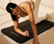 Dani in one-arm kneeling pose on cushion mat 