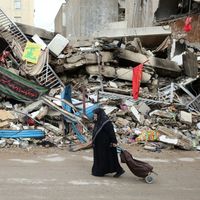 Une femme passe devant les destructions causées par le bombardement israélien dans le quartier de Shiyah, dans la banlieue sud de Beyrouth, le 28 novembre 2024