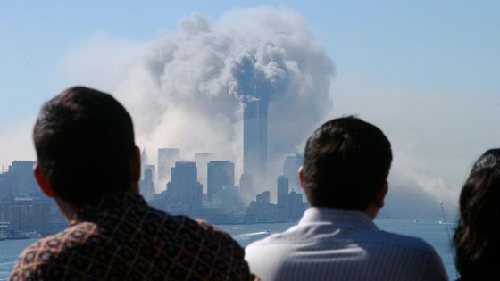 Des personnes observent l’attentat contre le World Trade Center, le 11 septembre 2001 à New York.