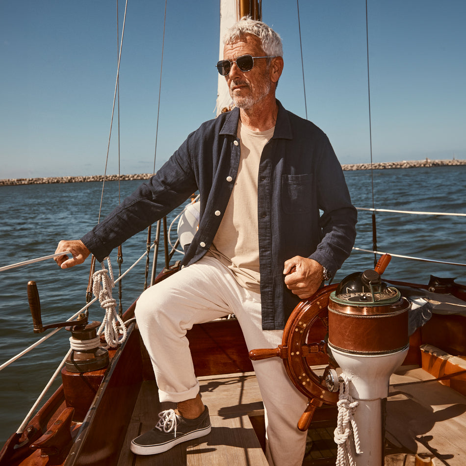 EDITORIAL IMAGE OF MODEL ON A SAILBOAT WEARING JOHNNY T-SHIRT AND CALLUM PANTS