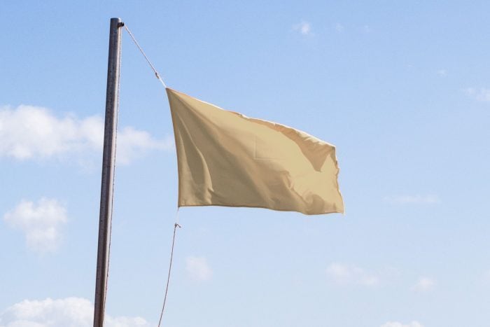 Beige flag flying on a flagpole