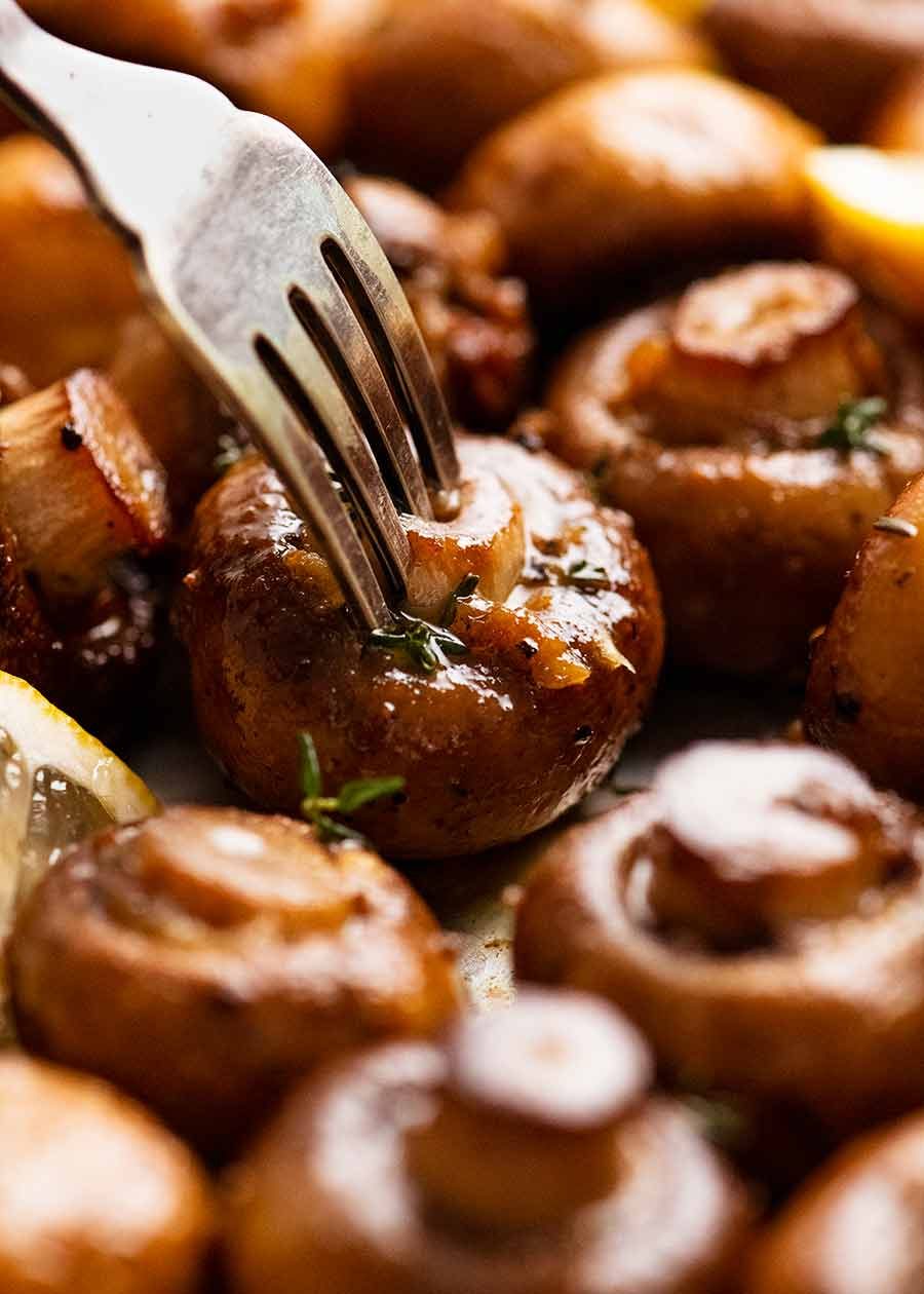 Fork picking up Garlic Butter Roasted Mushrooms