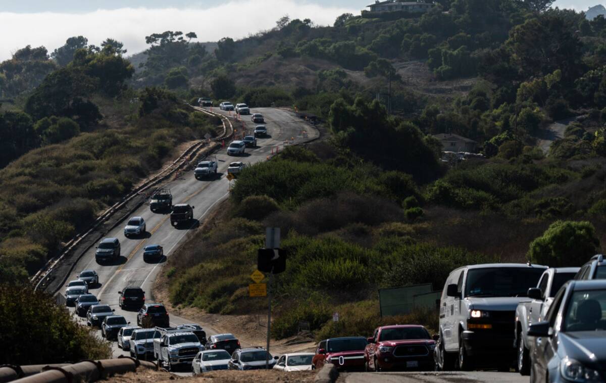 Motorists drive along a section of the road affected by ongoing landslides in Rancho Palos Verd ...