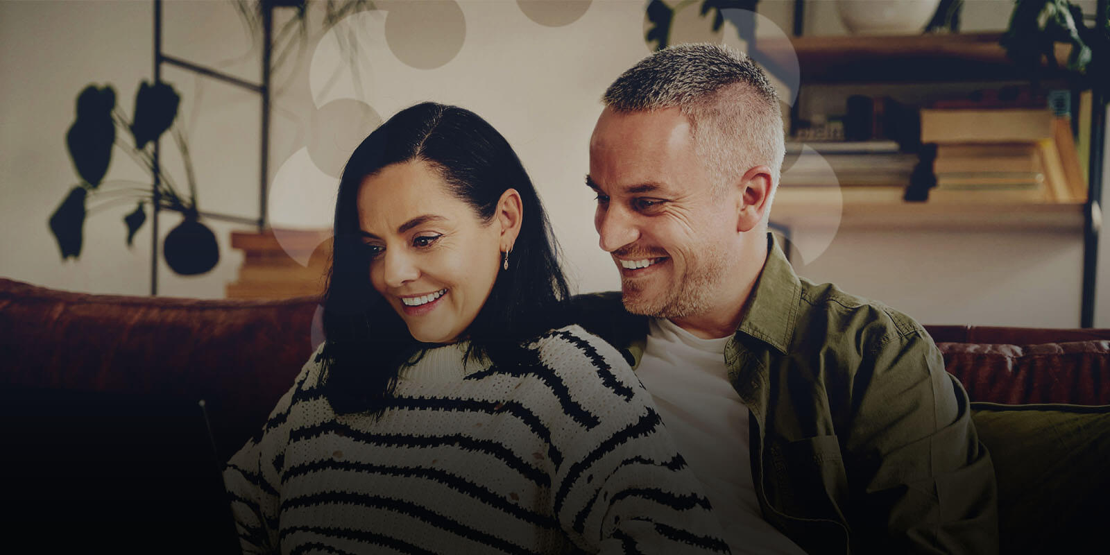 A smiling man and woman investing in precious metals