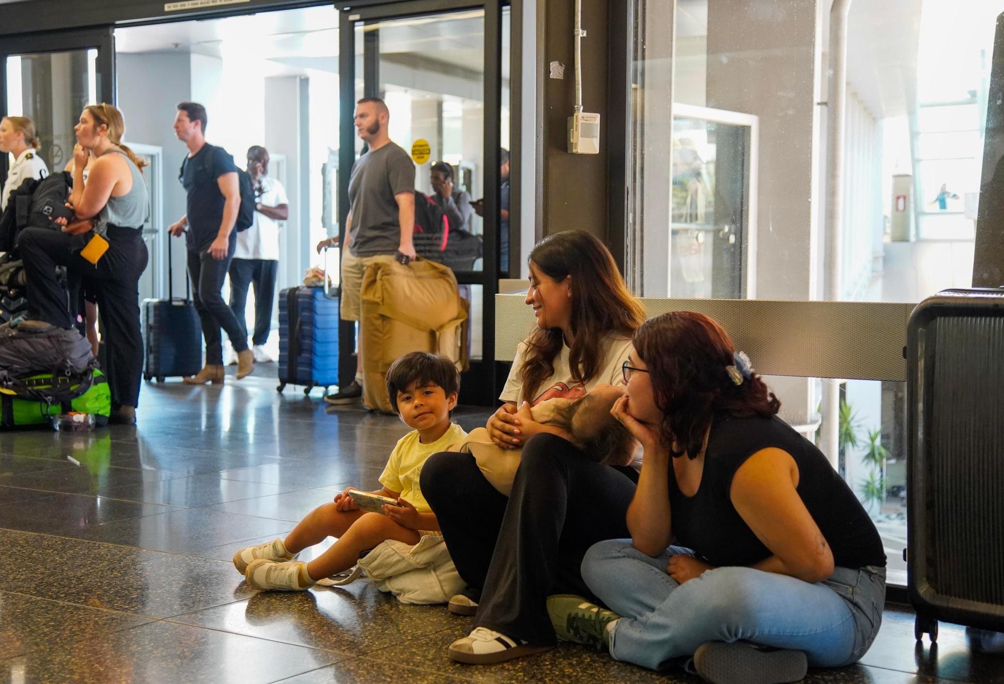 A widespread Microsoft outage disrupted flights at the San Diego International Airport on Friday, July 19, 2024 in San Diego, California. Sisters of Jose Mojarro, Berania sitting with her children and in the black Yasmin Mojarro wait in Terminal 2 to make sure their brother catches his flight. (Alejandro Tamayo / The San Diego Union-Tribune)