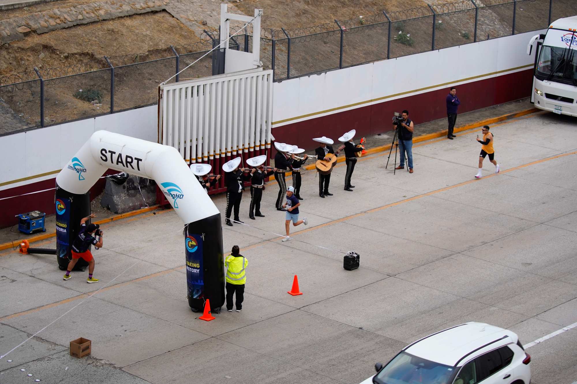 Runners compete in the Binational Race, from Las Americas Premium Outlets in San Ysidro to Playas de Tijuana. A group of runners enter Tijuana and are greeted by a Mariachi group in El Chaparral on Sunday, Sept. 15, 2024 in Tijuana, Baja California. (Alejandro Tamayo / The San Diego Union-Tribune)