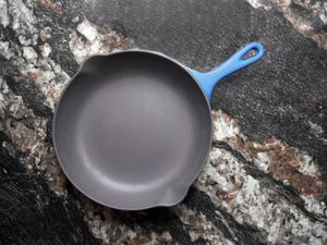 Vintage Le Creuset Enameled cast iron skillet on a black marble backdrop