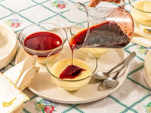 Side view of pouring syrup onto puddings.