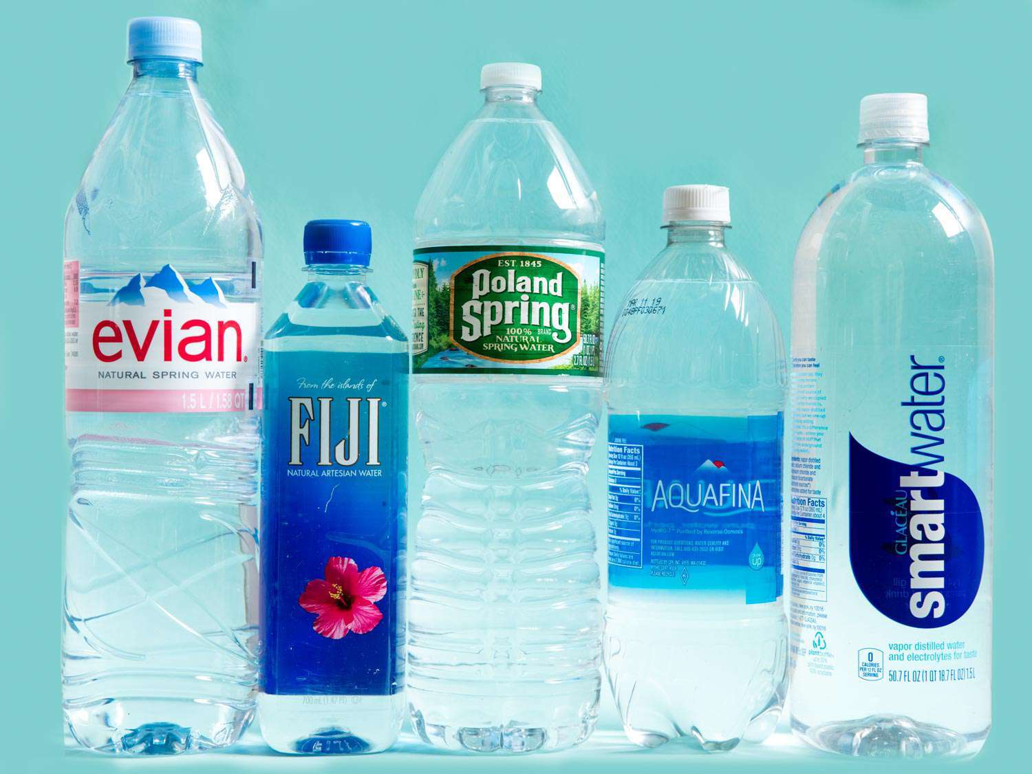 A profile shot of 5 different brands of bottled water.