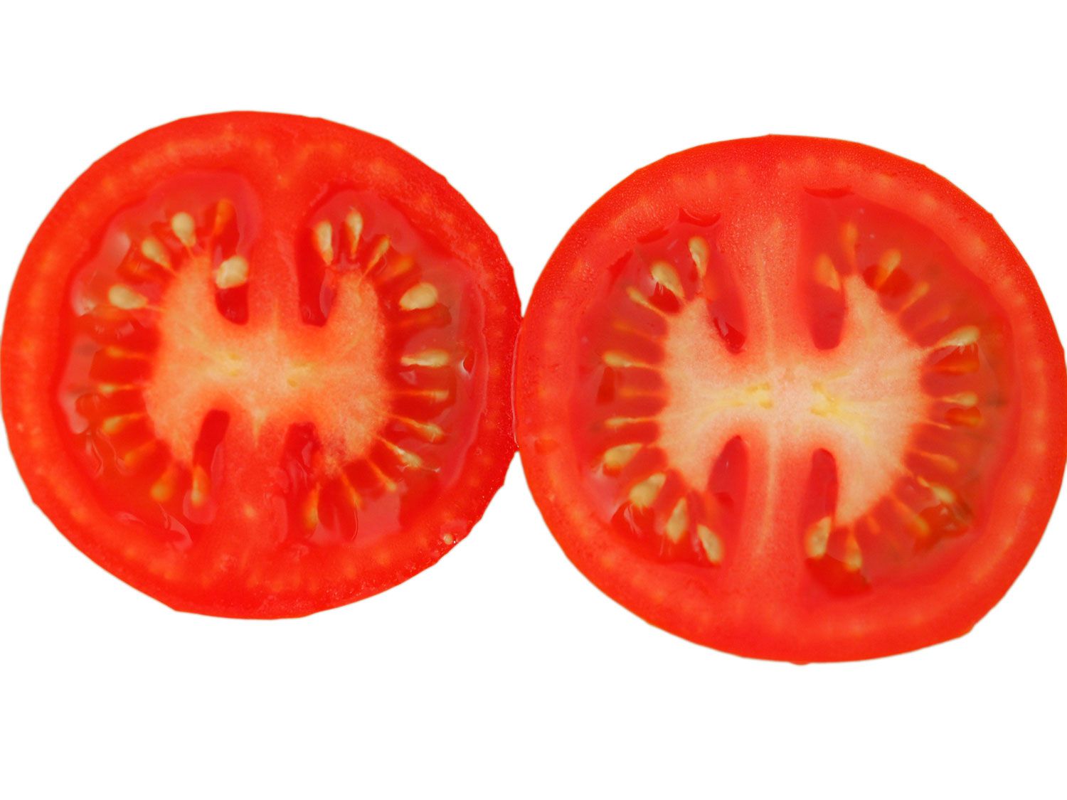 An overhead look at two cherry tomatoes cut in half so you can see inside.