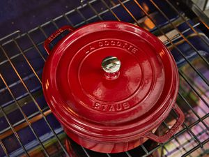 a red Staub dutch oven on an oven's rack