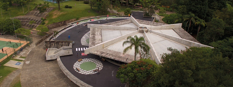 Fotografia aérea do ginásio mostra a cobertura do telhado, em forma hexagonal, bem como o mezanino, onde há uma pista de skate.