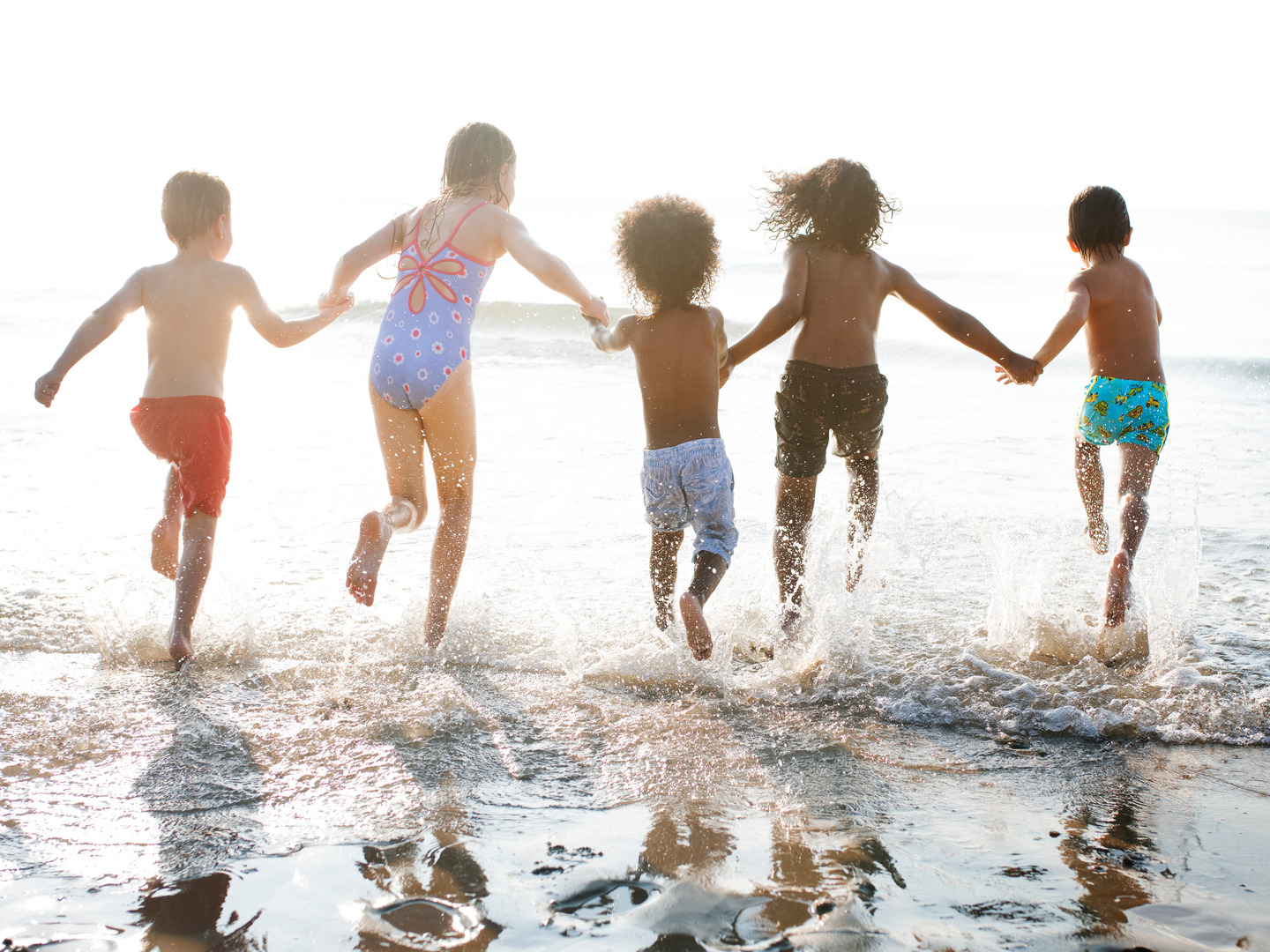 Kids running into ocean