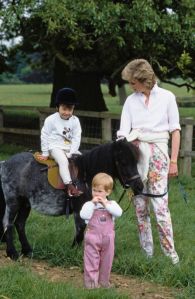 British Royal Prince William riding Smokey the pony as his mother, Diana, Princess of Wales (1961-1997), wearing a white shirt and floral pattern trousers, and his brother Prince Harry look on, on the Highgrove Estate in Doughton, Gloucestershire, England, 18th July 1986. (Photo by Tim Graham Photo Library via Getty Images)