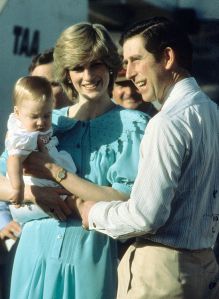 ALICE SPRINGS, AUSTRALIA - MARCH 20: Prince Charles, Prince of Wales and Diana, Princess of Wales, wearing a turquoise silk calf length button down dress with a large frill collar designed by Jan Van Velden and carrying baby Prince William, arrive at Alice Springs Airport at the start of their tour of Australia on March 20, 1983 in Alice Springs, Australia. (Photo by Anwar Hussein/Getty Images)