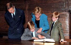 Prince William follows Eton tradition by signing a book before starting at the school, as Prince Charles, Princess Diana (1961 - 1997) and Prince Harry look on, 6th September 1995.  (Photo by Jayne Fincher/Getty Images)