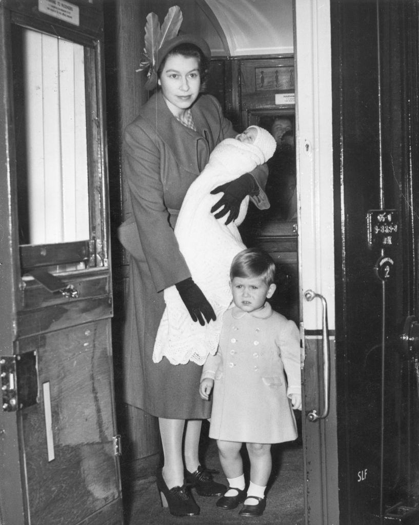 15th September 1950:  Princess Elizabeth boards a first class railway carriage, en route to Balmoral Castle, Scotland. She is carrying Princess Anne while Prince Charles stands beside her.  (Photo by Reg Speller/Fox Photos/Hulton Archive/Getty Images)