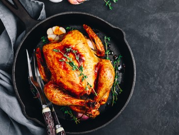 Grilled fried roasted whole Chicken in cast iron pan on dark concrete  background, top view, copy space