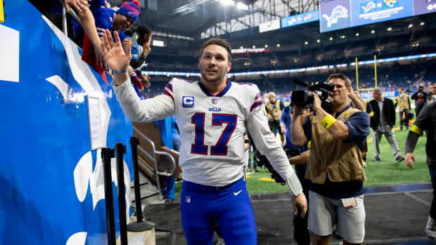 Josh Allen high fives fans as he walks off the field