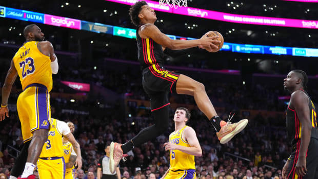 Mar 18, 2024; Los Angeles, California, USA; Atlanta Hawks forward Jalen Johnson (1) dunks the ball against Los Angeles Lakers forward LeBron James (23) in the first half at Crypto.com Arena. Mandatory Credit: Kirby Lee-USA TODAY Sports