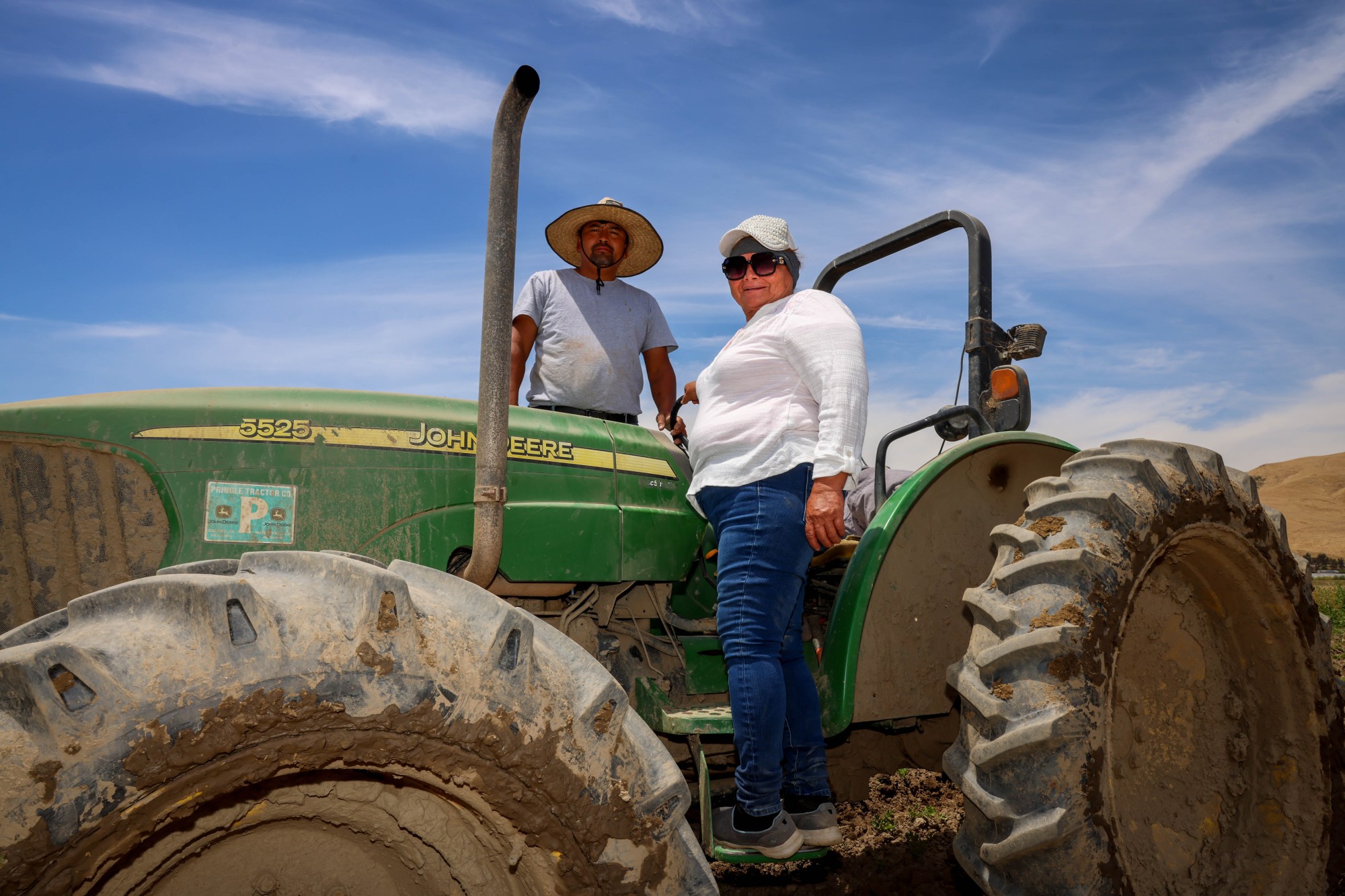Maria Catalan, right, founder of the organic Catalan Family Farms, stands on a tractor operated by her son, Julio Catalan, in the 55-acre land she leases in Hollister, Calif., on Tuesday, June 19, 2024. (Ray Chavez/Bay Area News Group)