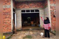 Salmah menunjukkan rumahnya yang terbengkalai yang menjadi tempat mereka anak beranak berteduh.