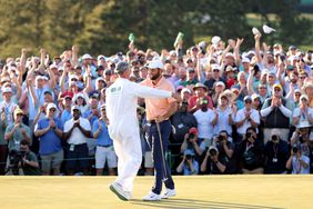 Scottie Scheffler of the United States and caddie Ted Scott celebrate on the 18th green after winning the 2024 Masters Tournament at Augusta National Golf Club