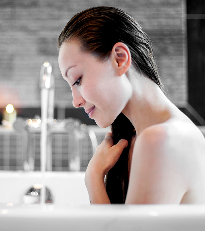 A curly hair girl applying heat protectant on her hair