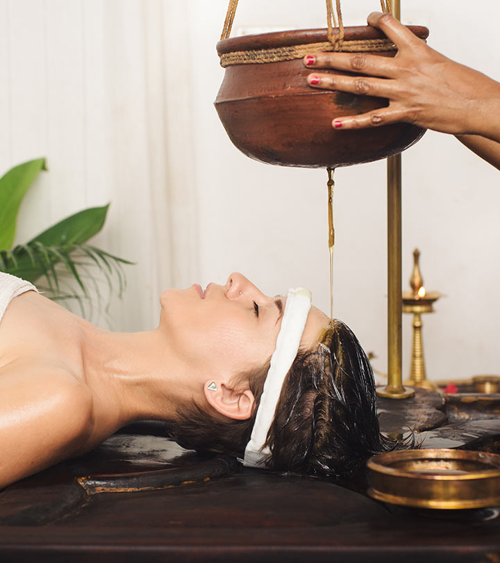 A girl applying some hair oin in a traditional method