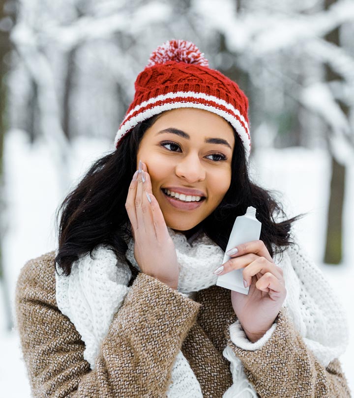 A girl applying some skin products in a snowy region