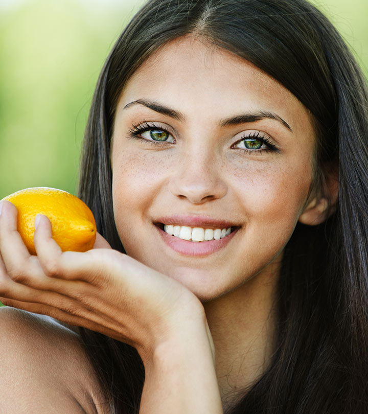 A woman holding lemon in her hand