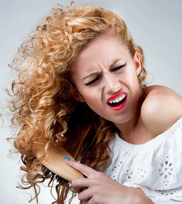 A curly hair girl applying heat protectant on her hair