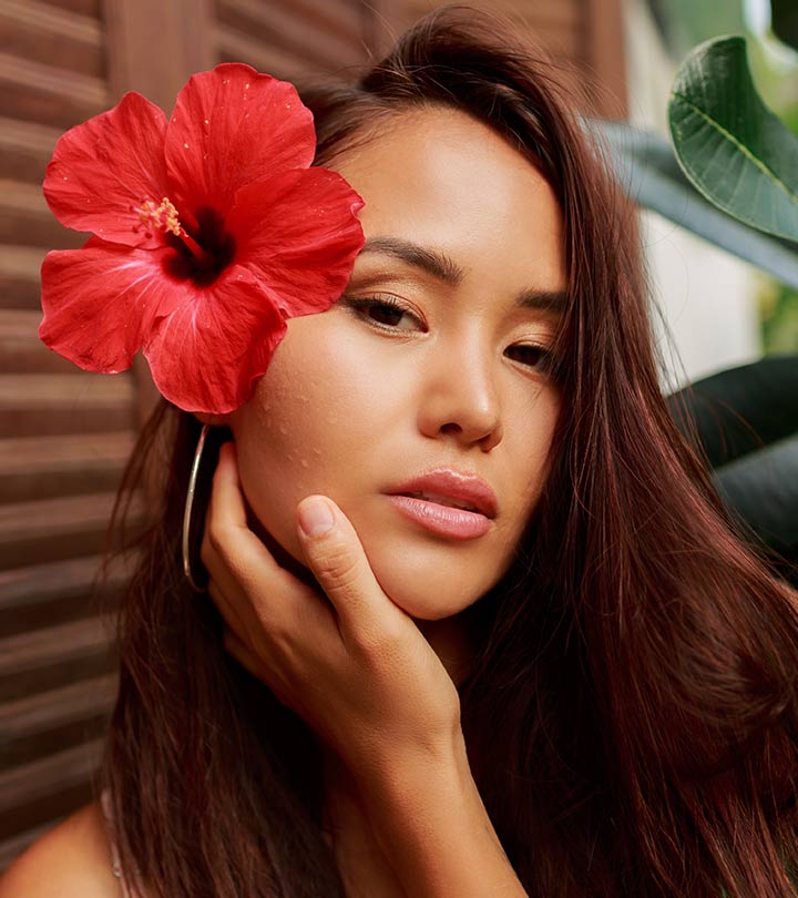 A girl attached a hibiscus flower to her hair