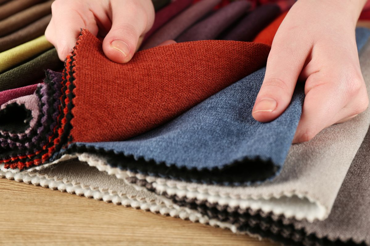 A woman tests if polyester fabric stretches while checking its durability.