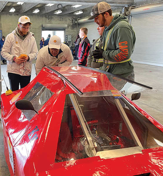 SwRI staff member Logan Elliott and consultant Joe Redfield check Kankakee Valley High School’s urban concept internal combustion engine vehicle.