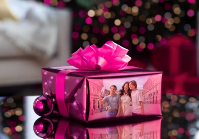 A gift box with a reflection of a mom taking a group selfie with her two kids