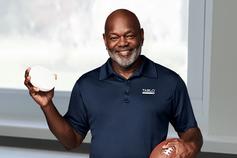 Happy Emmit Smith Holding a Tablo Smart DVR in His Hand