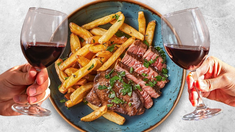 hands holding wine by steak frites