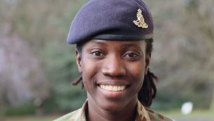 A woman in an army uniform smiling