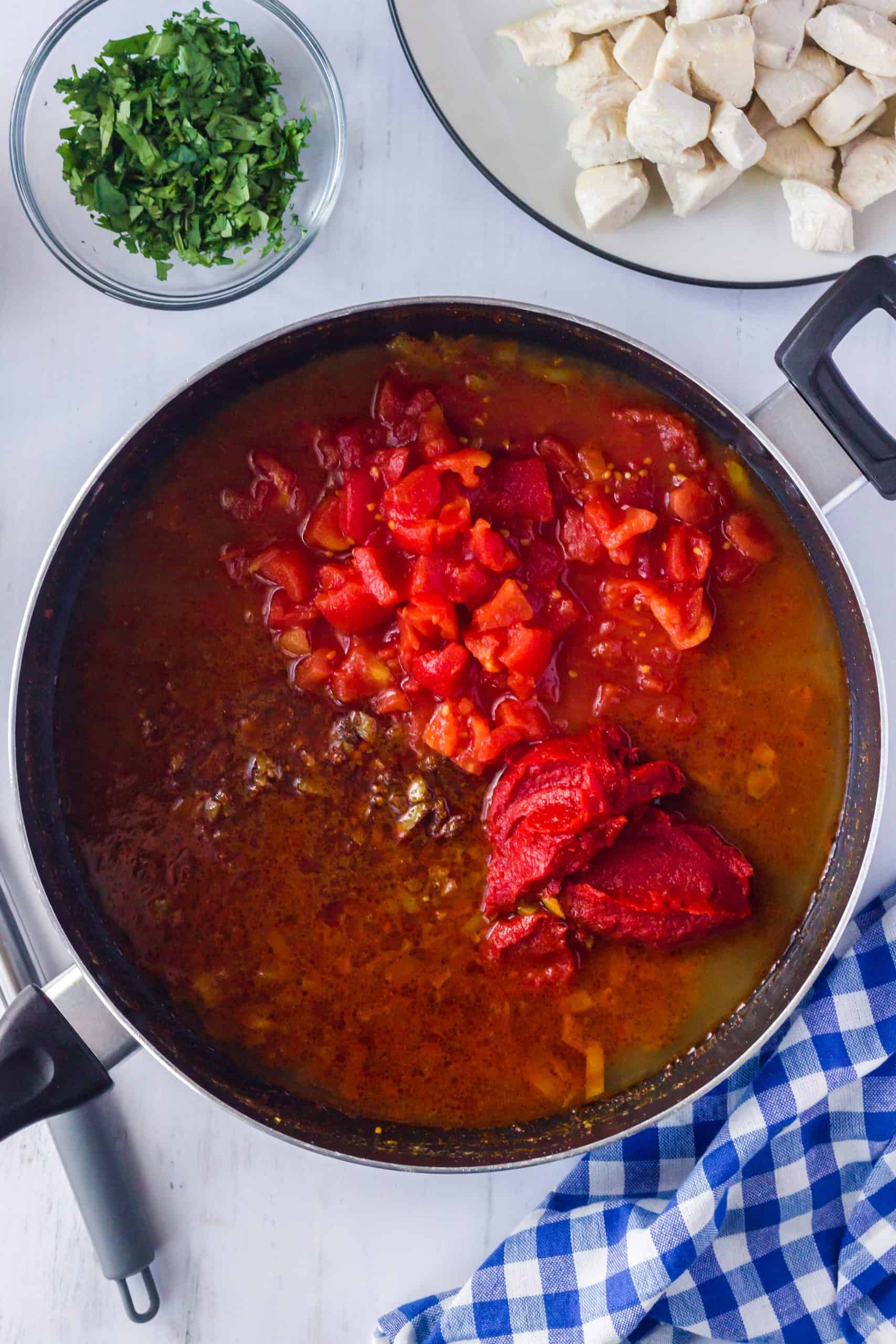 Diced tomatoes, tomato paste and chicken broth added to skillet not stirred.