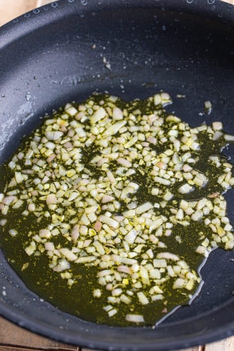 Olive oil and shallots in a skillet.