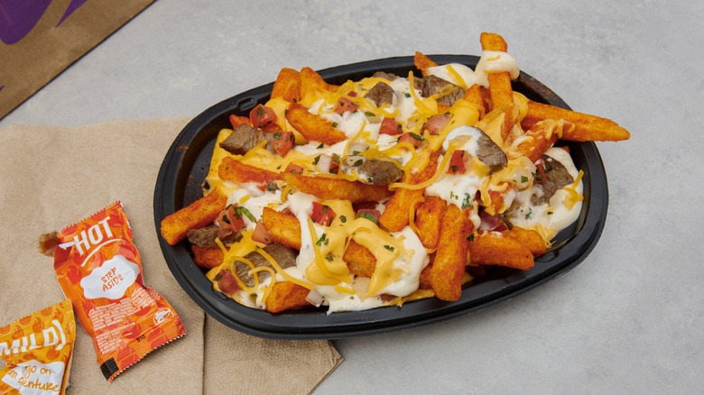 Steak nacho garlic fries topped with cheese and sour cream